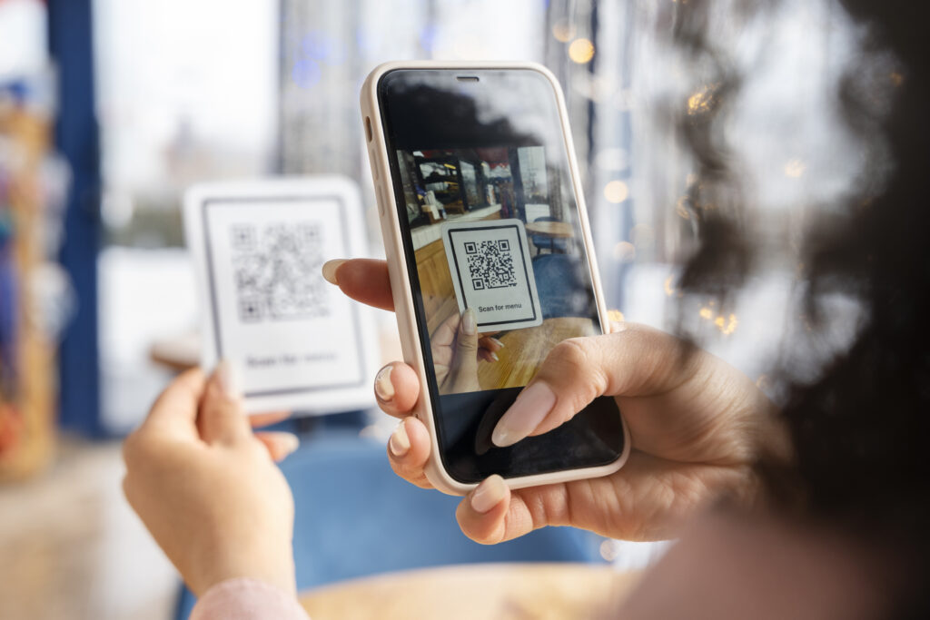 Celular lendo qr code em restaurante, para acessar cardápio digital
