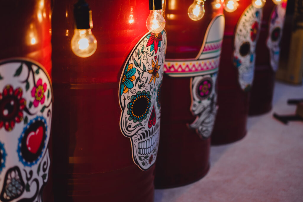 Decoração de restaurante mexicano, com luzes e caveiras mexicanas em tambores vermelhos.