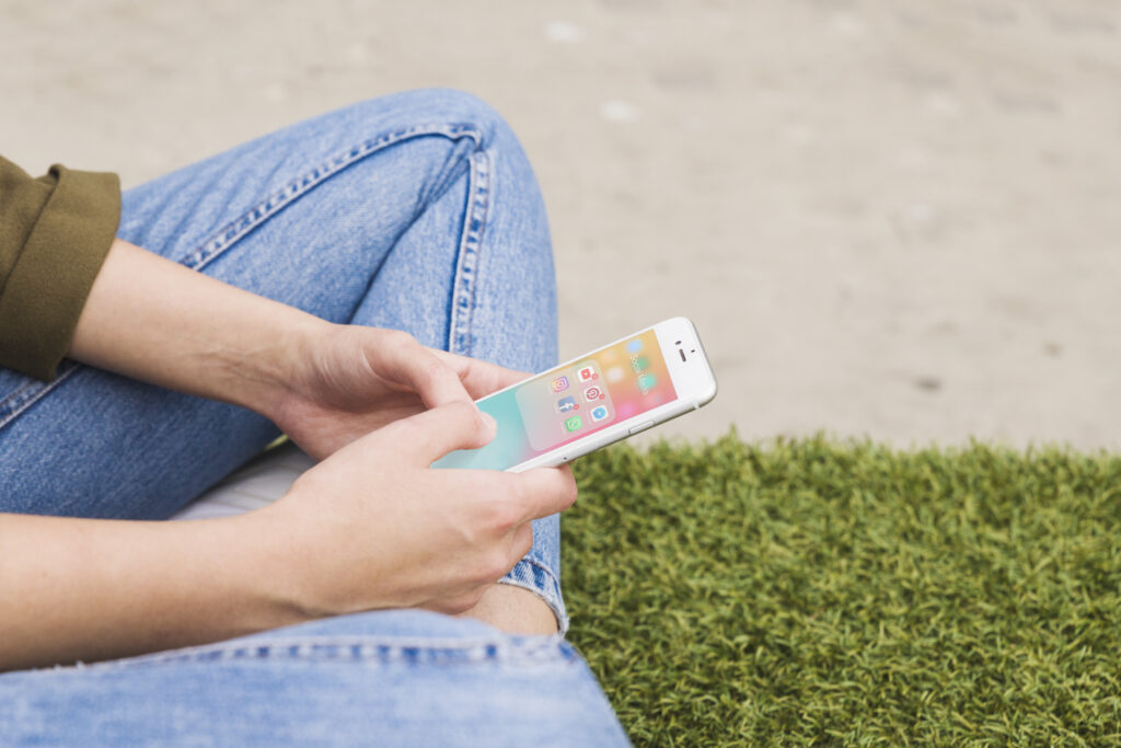 Mãos mexendo em celular.
