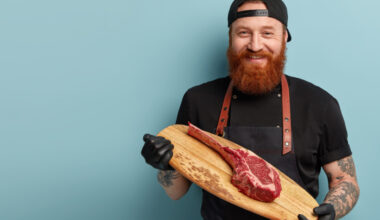 fundo azul; chef segurando tábua com grande pedaço de carne