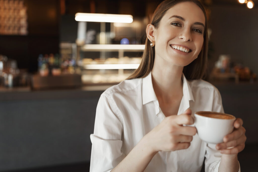 Moça em lanchonete tomando café 