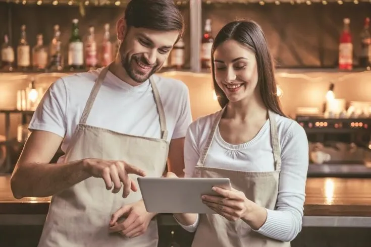 dois garçons sorrindo para um tablet